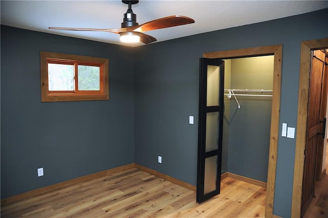 unfurnished bedroom with ceiling fan, a closet, and light wood-type flooring