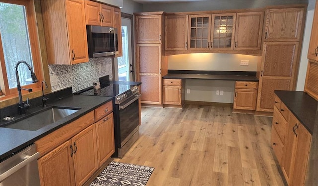 kitchen with stainless steel appliances, light hardwood / wood-style flooring, tasteful backsplash, and sink