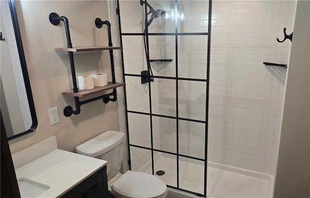 bathroom with vanity, toilet, and a tile shower