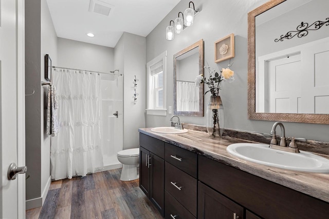 bathroom with a shower with shower curtain, vanity, toilet, and wood-type flooring