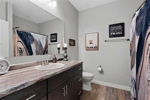 bathroom featuring toilet, vanity, and hardwood / wood-style flooring