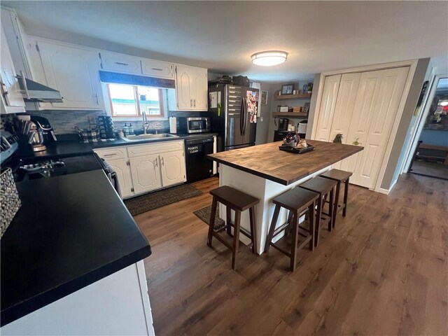 kitchen featuring a breakfast bar, white cabinets, sink, a kitchen island, and stainless steel appliances