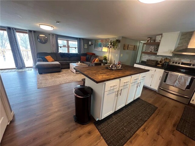 kitchen with wood counters, electric range, white cabinets, a center island, and dark hardwood / wood-style floors