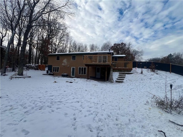 snow covered back of property featuring a wooden deck and central AC