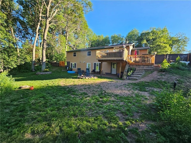 back of property with a yard and a wooden deck