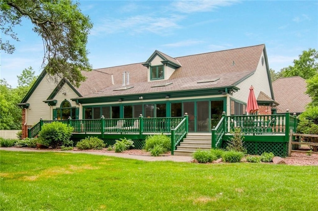 view of front facade with a sunroom, a deck, and a front yard