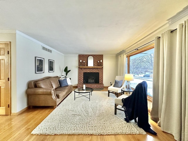 living room featuring a brick fireplace, light hardwood / wood-style flooring, and ornamental molding