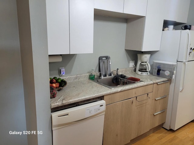 kitchen featuring sink, light hardwood / wood-style flooring, white appliances, light brown cabinetry, and white cabinets