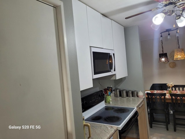 kitchen featuring white cabinetry, ceiling fan, decorative light fixtures, and range