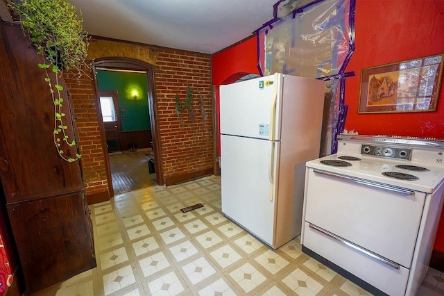 kitchen with brick wall and white appliances