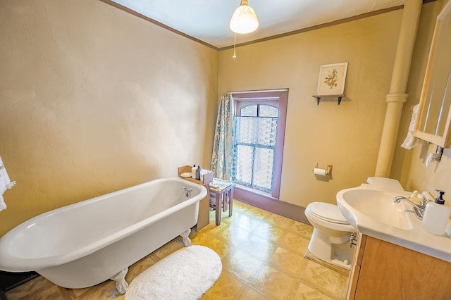 bathroom featuring a washtub, vanity, toilet, and ornamental molding