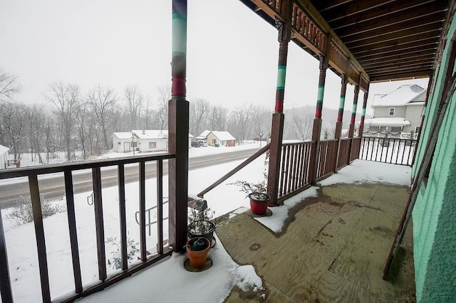 view of snow covered back of property