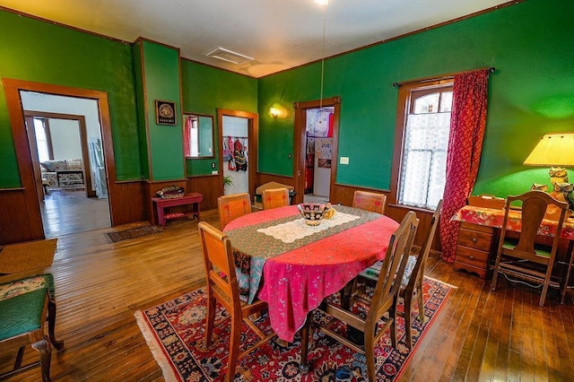 dining room featuring hardwood / wood-style flooring and wood walls