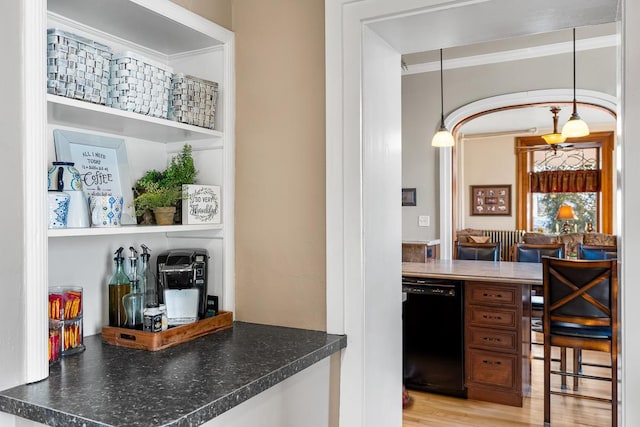 bar featuring light wood-type flooring, black dishwasher, decorative light fixtures, and ornamental molding