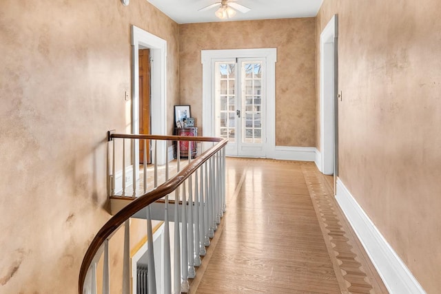 corridor with wood-type flooring and french doors