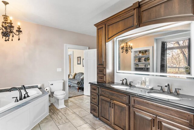 bathroom featuring a washtub, vanity, toilet, and tile patterned flooring