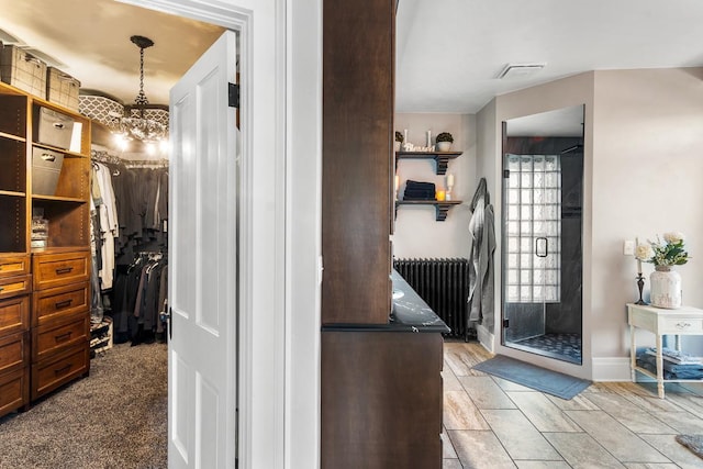 bathroom featuring a notable chandelier and radiator heating unit