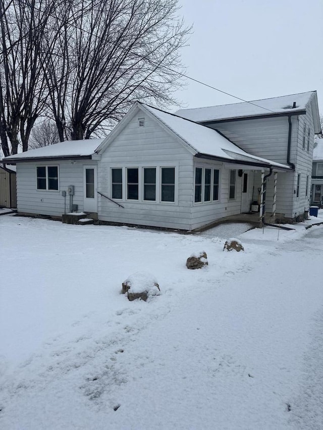 view of snow covered rear of property