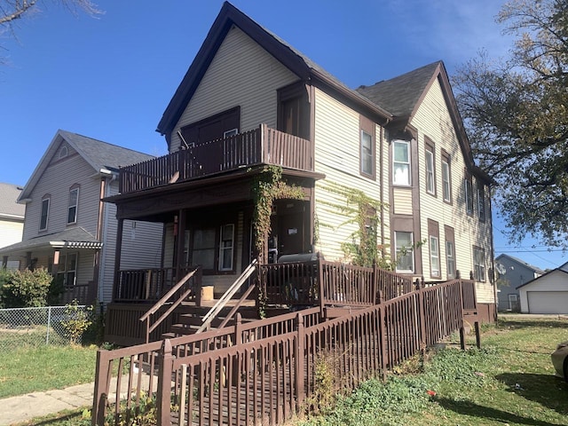 view of front of property featuring a balcony, a porch, and fence