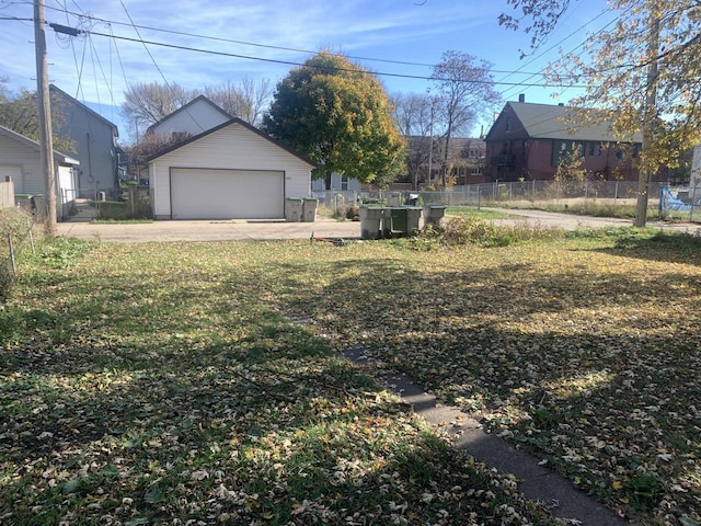 view of yard featuring an outbuilding, a garage, and fence