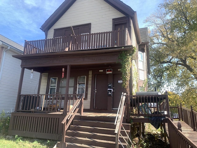 view of front of house featuring stairs, a balcony, and covered porch