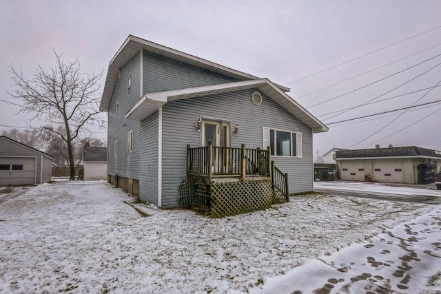 snow covered back of property with an outdoor structure