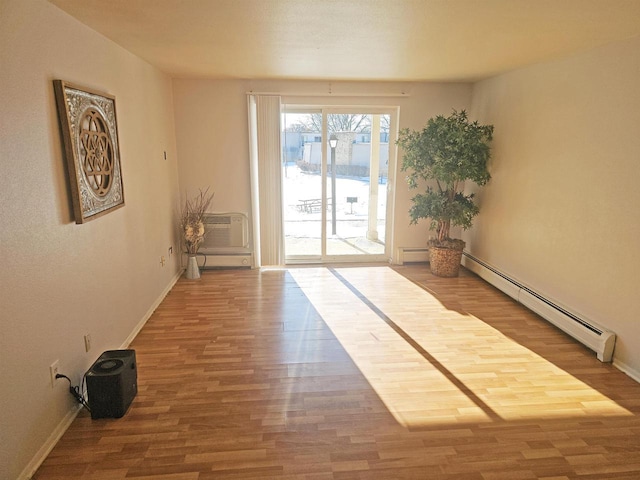 doorway to outside featuring baseboard heating, a wall mounted AC, and hardwood / wood-style floors