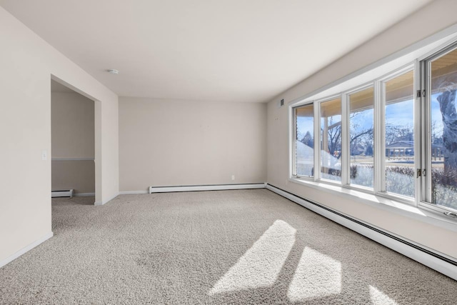 unfurnished room featuring carpet, a baseboard radiator, and plenty of natural light