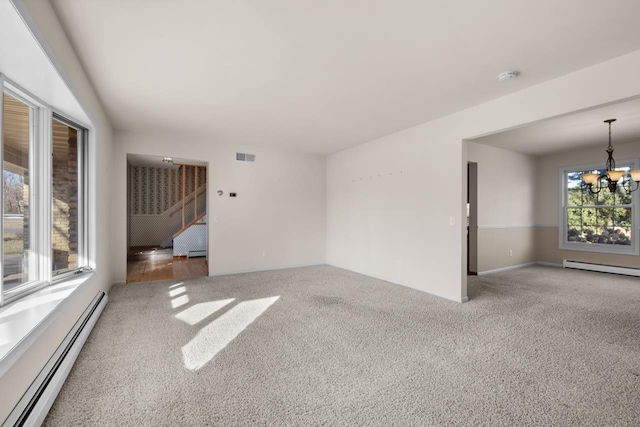 spare room featuring a chandelier, plenty of natural light, carpet floors, and a baseboard radiator