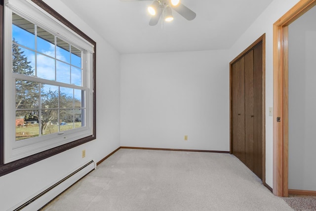 unfurnished bedroom with ceiling fan, light colored carpet, and a baseboard radiator