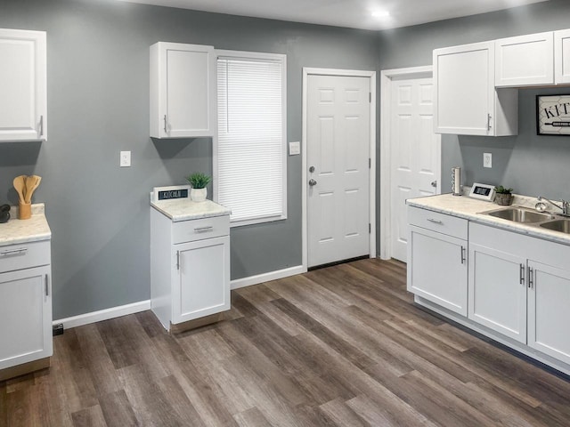 kitchen with white cabinets, dark wood-type flooring, and sink