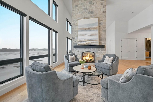 living room featuring a fireplace, a water view, and light hardwood / wood-style flooring