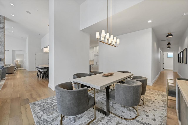 dining room with light wood-type flooring and an inviting chandelier