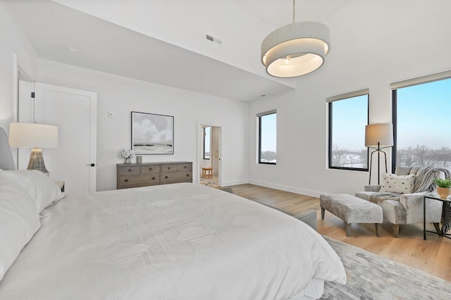 bedroom with hardwood / wood-style floors and multiple windows