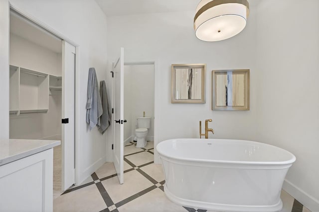 bathroom with tile patterned floors, vanity, toilet, and a bathtub