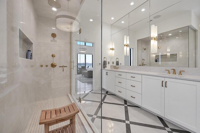 bathroom with tile patterned flooring, vanity, and walk in shower