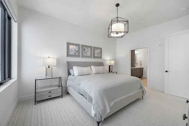 carpeted bedroom with ensuite bath and multiple windows