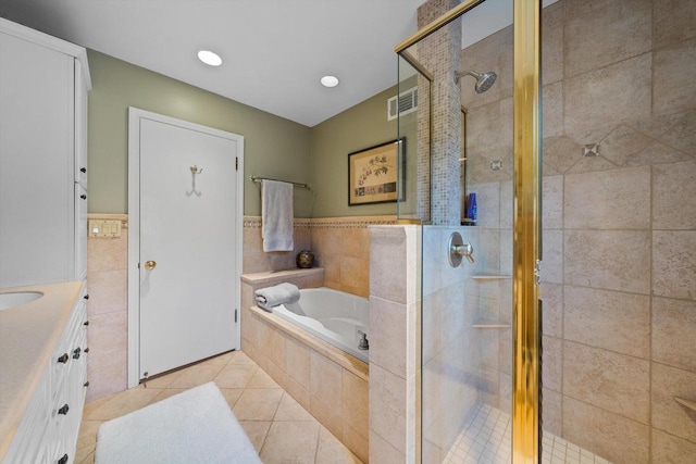 bathroom featuring vanity, tile patterned flooring, tile walls, and independent shower and bath