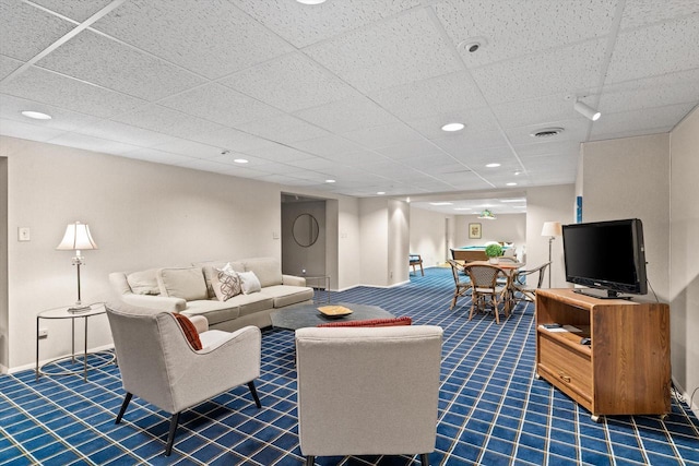 carpeted living room with a paneled ceiling