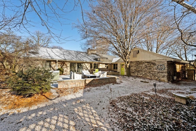 snow covered house featuring a patio