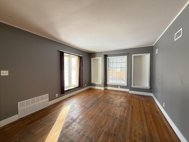 empty room with wood-type flooring and crown molding