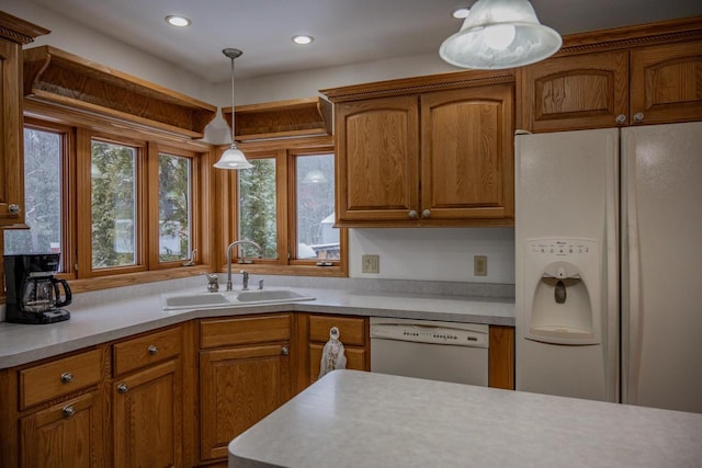 kitchen featuring sink, white appliances, and decorative light fixtures