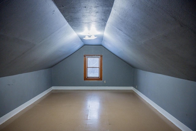 bonus room with lofted ceiling and a textured ceiling