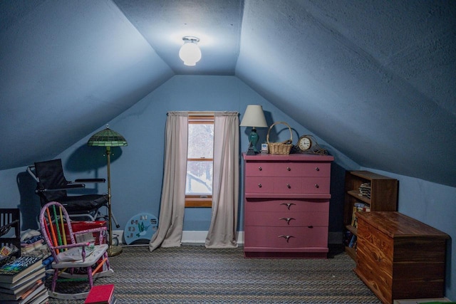 additional living space featuring dark carpet, vaulted ceiling, and a textured ceiling