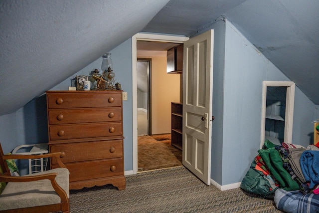 additional living space with lofted ceiling, dark carpet, and a textured ceiling