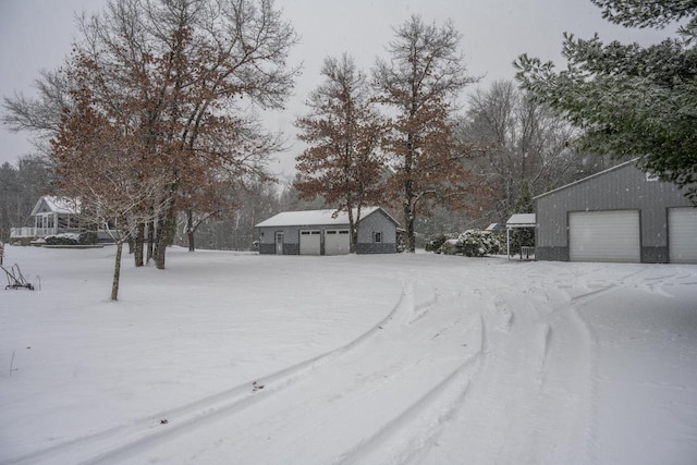 yard layered in snow with an outbuilding and a garage