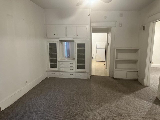 unfurnished bedroom with ceiling fan, carpet floors, and white refrigerator