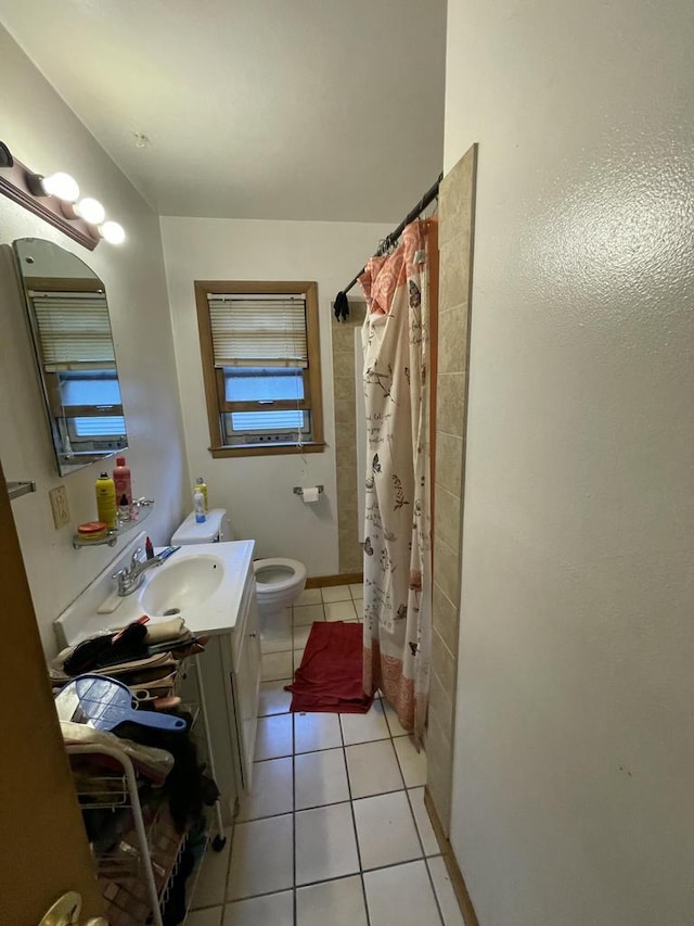 bathroom with toilet, tile patterned flooring, vanity, and walk in shower