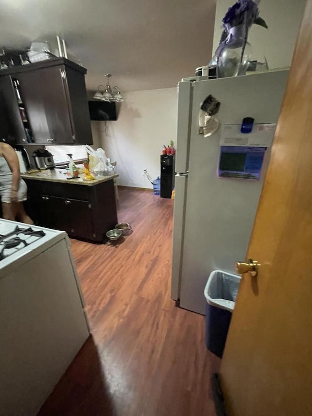 kitchen featuring white range oven, stainless steel refrigerator, and dark wood-type flooring