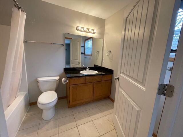 full bathroom with tile patterned flooring, vanity, shower / bath combination with curtain, and toilet